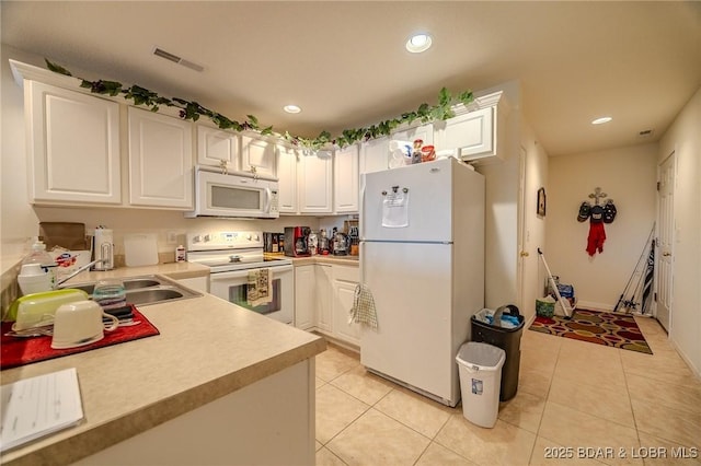 kitchen with visible vents, white appliances, light countertops, white cabinetry, and a sink