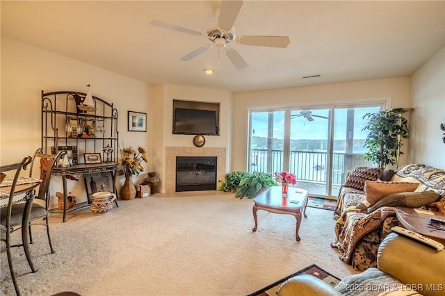 carpeted living room featuring a fireplace, a ceiling fan, and visible vents