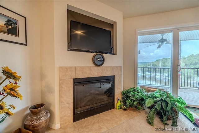 room details featuring a ceiling fan and a tiled fireplace