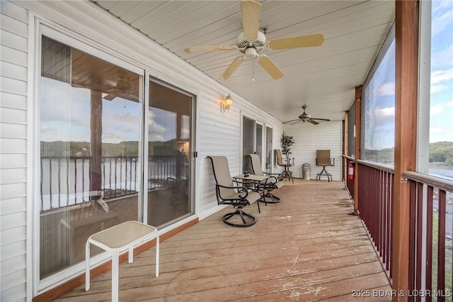 sunroom with a water view and ceiling fan
