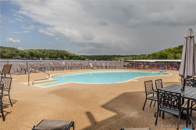 community pool with fence and a patio area