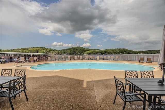 pool featuring fence, a patio, and outdoor dining space