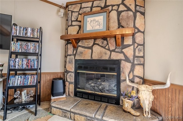 122 Simpson Rd, Urbana, MO 65767 - interior details featuring crown molding, wooden walls, a stone fireplace, and a wainscoted wall