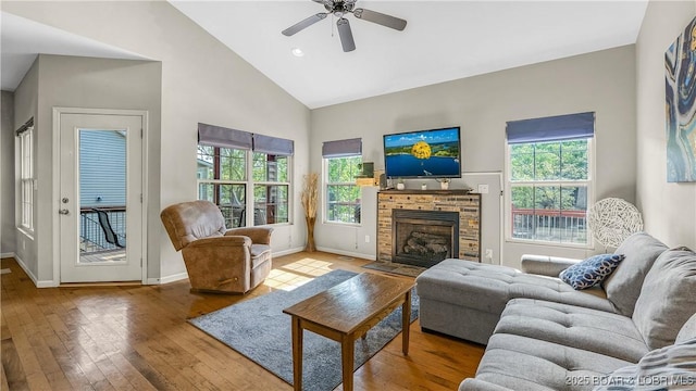 living area featuring high vaulted ceiling, plenty of natural light, baseboards, and hardwood / wood-style floors