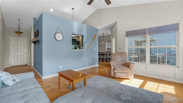 living room with baseboards, ceiling fan, and wood finished floors