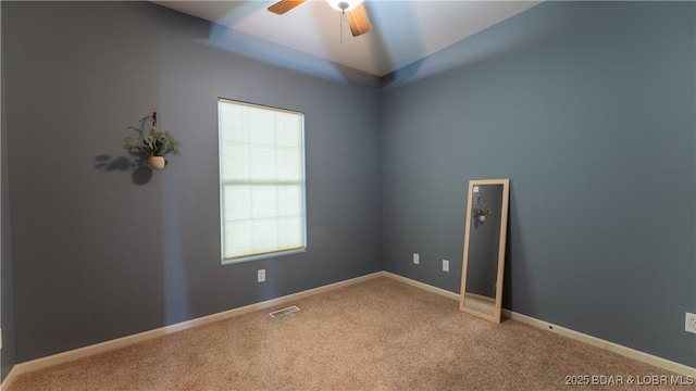 empty room featuring carpet floors, ceiling fan, visible vents, and plenty of natural light
