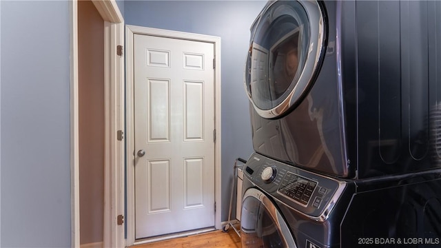 washroom with laundry area, stacked washer and dryer, and light wood-style flooring