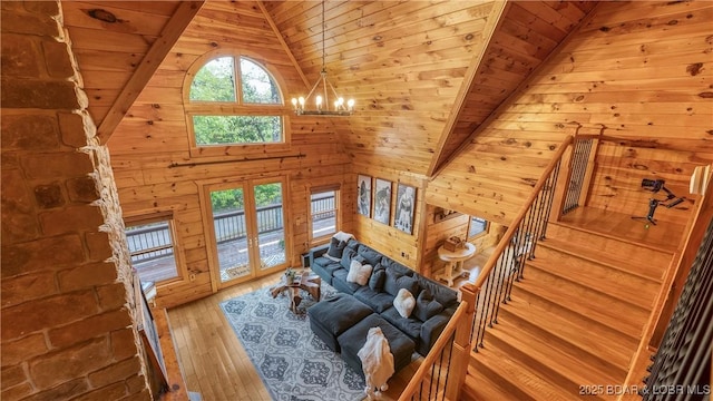 living area with wood ceiling, a chandelier, hardwood / wood-style flooring, wood walls, and lofted ceiling