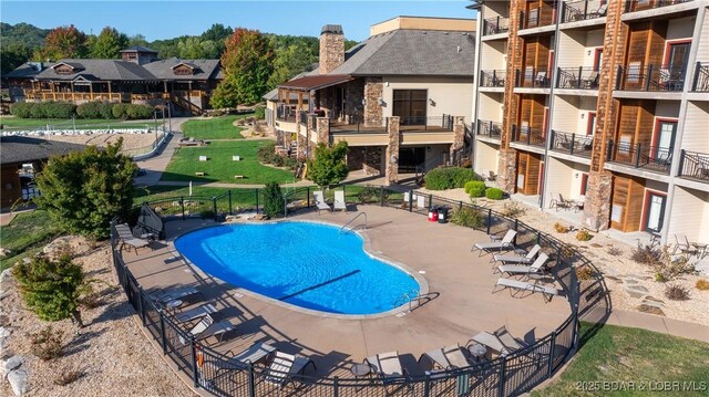 pool featuring fence, a patio area, and a residential view