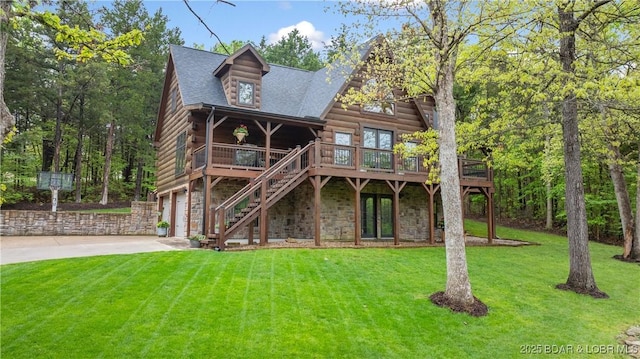 rear view of house with driveway, log exterior, an attached garage, a yard, and stairway