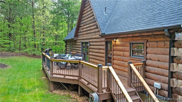 deck featuring outdoor dining area, a yard, and stairway