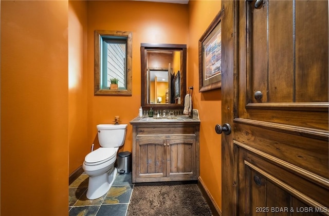 32 Wild Pines Ct, Sunrise Beach, MO 65079 - half bathroom with toilet, vanity, baseboards, and stone finish flooring