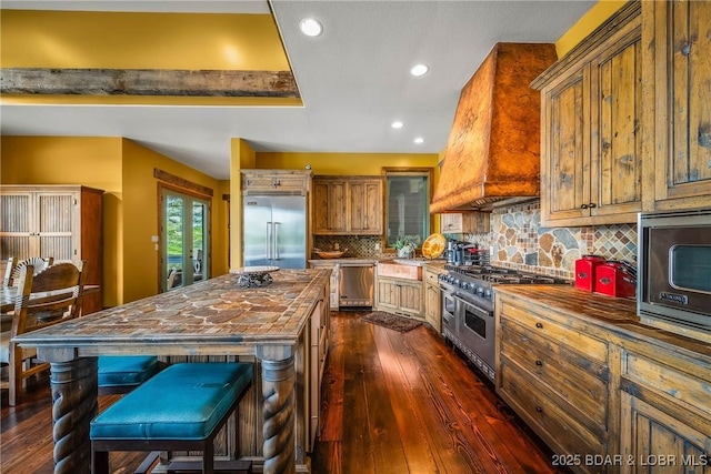 32 Wild Pines Ct, Sunrise Beach, MO 65079 - kitchen with butcher block counters, built in appliances, dark wood-style floors, custom exhaust hood, and recessed lighting