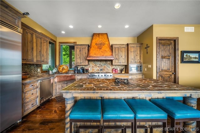 32 Wild Pines Ct, Sunrise Beach, MO 65079 - kitchen with built in appliances, custom range hood, dark wood-style flooring, backsplash, and recessed lighting