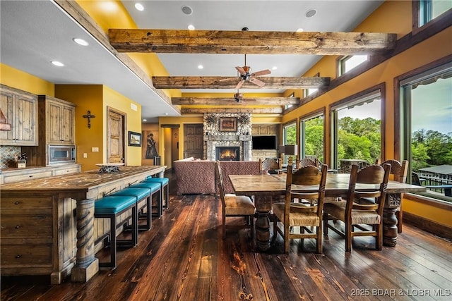 32 Wild Pines Ct, Sunrise Beach, MO 65079 - dining area featuring dark wood-style floors, a ceiling fan, recessed lighting, beamed ceiling, and a fireplace