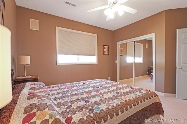 carpeted bedroom with a ceiling fan, visible vents, multiple windows, and a closet