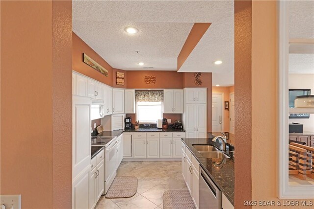 kitchen with a textured ceiling, dishwasher, a sink, white electric range oven, and a textured wall