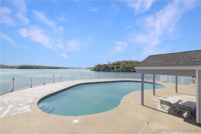 view of pool with fence, a patio, and a water view