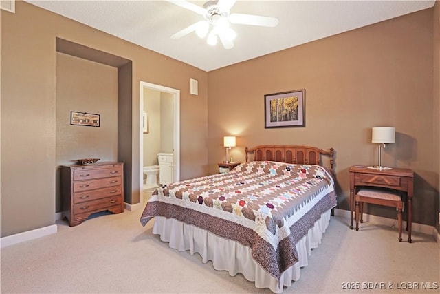 bedroom with visible vents, baseboards, ensuite bathroom, and light carpet