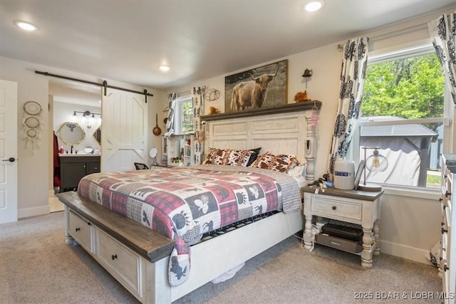 bedroom featuring carpet floors, recessed lighting, a barn door, and ensuite bath