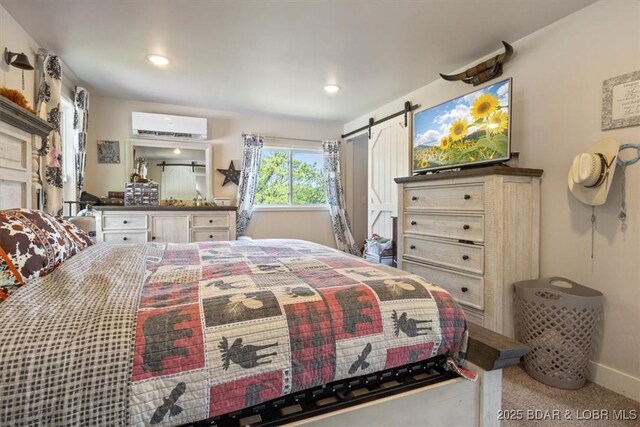 carpeted bedroom featuring recessed lighting, a barn door, baseboards, and a wall mounted air conditioner
