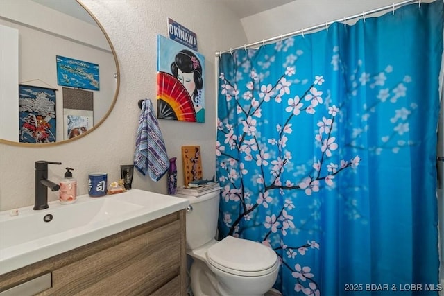 bathroom featuring vanity, a textured wall, toilet, and a shower with shower curtain