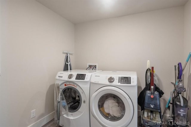 clothes washing area with laundry area, baseboards, and washing machine and dryer