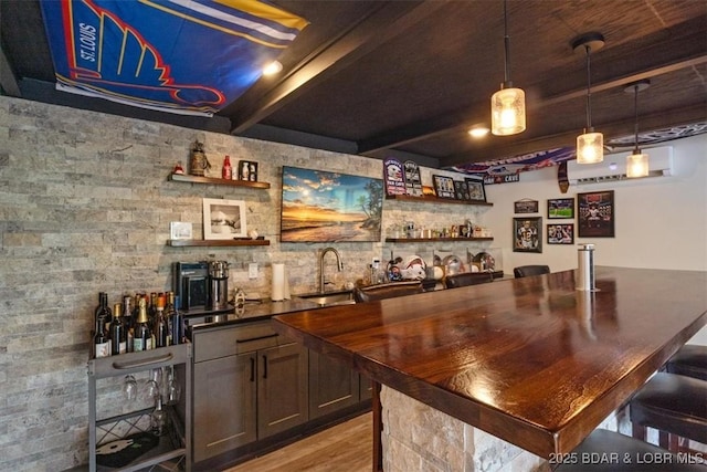 bar featuring pendant lighting, a wall mounted AC, beamed ceiling, indoor wet bar, and light wood-style floors