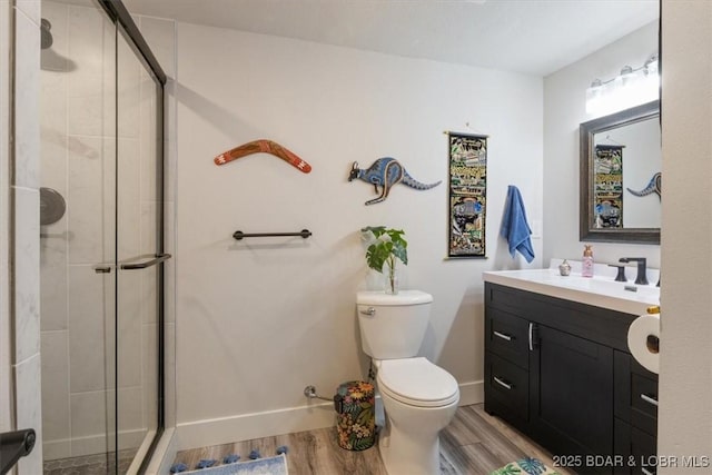 full bathroom featuring baseboards, a shower stall, toilet, and wood finished floors