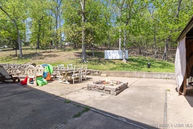 view of patio with fence and a fire pit