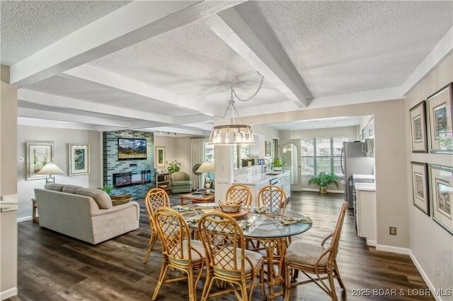 dining space featuring dark wood-type flooring, a textured ceiling, and beamed ceiling