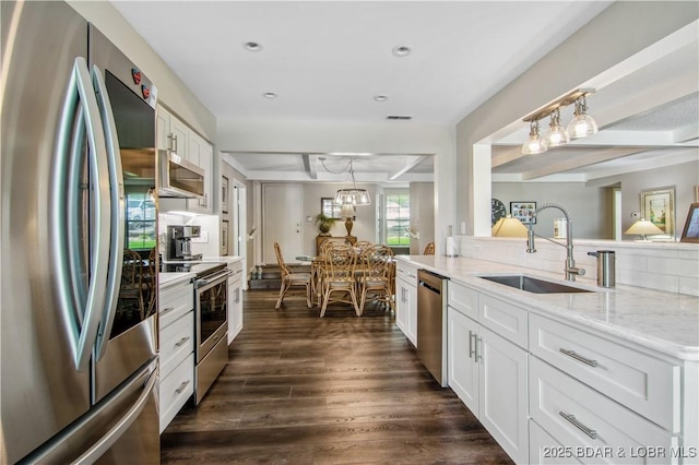 kitchen featuring a sink, appliances with stainless steel finishes, white cabinets, and dark wood finished floors