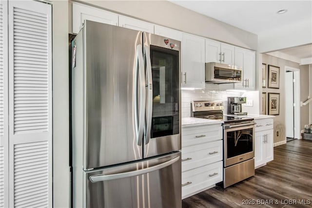 kitchen with backsplash, dark wood-style flooring, light countertops, stainless steel appliances, and white cabinetry