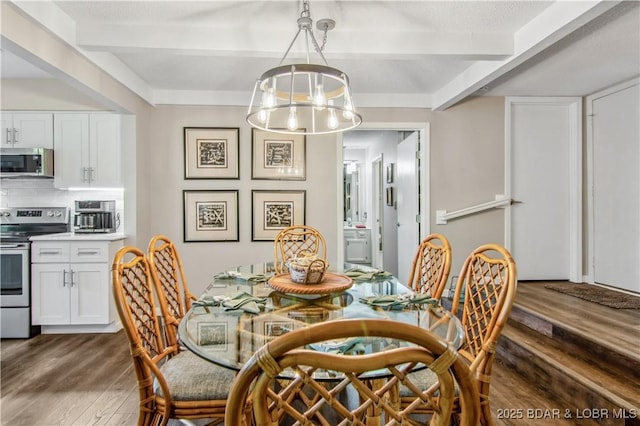 dining area with an inviting chandelier, dark wood finished floors, and beam ceiling