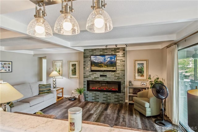 living room featuring baseboards, wood finished floors, a fireplace, and beamed ceiling