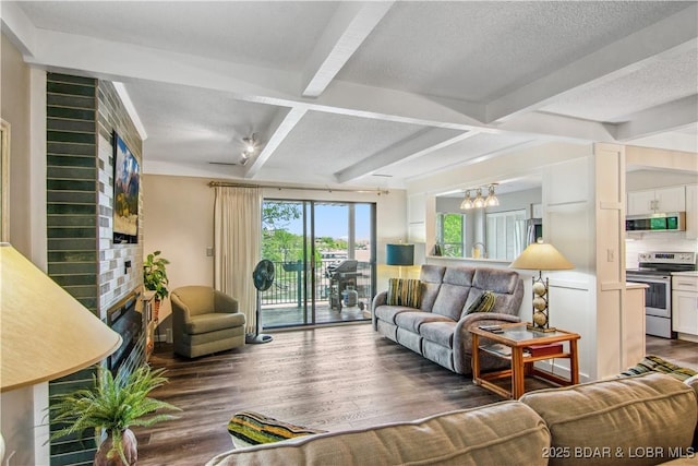 living room with an inviting chandelier, a brick fireplace, wood finished floors, beamed ceiling, and coffered ceiling