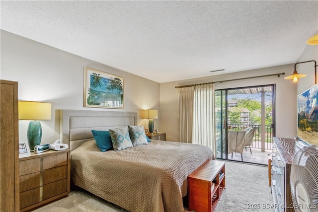 bedroom featuring a textured ceiling, access to exterior, and carpet