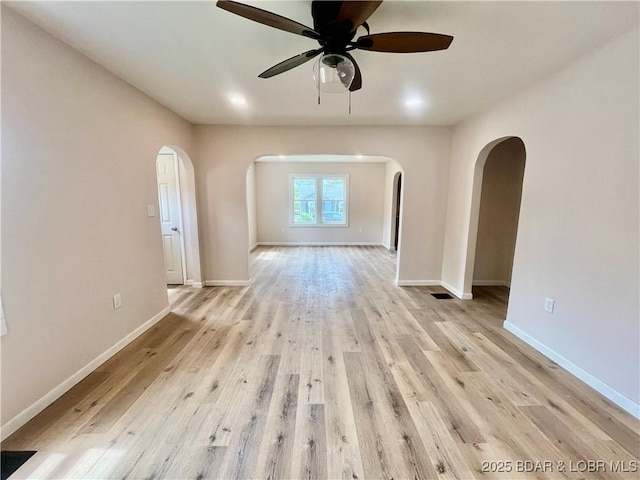407 Cleveland St, Versailles, MO 65084 - unfurnished room with ceiling fan, arched walkways, baseboards, light wood-type flooring, and visible vents