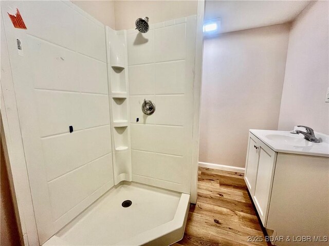 407 Cleveland St, Versailles, MO 65084 - full bathroom featuring baseboards, walk in shower, wood finished floors, and vanity