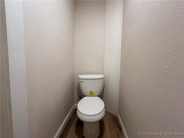 407 Cleveland St, Versailles, MO 65084 - bathroom with baseboards, a textured wall, toilet, and wood finished floors