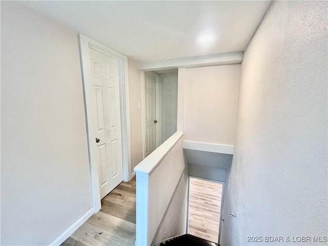 407 Cleveland St, Versailles, MO 65084 - hallway featuring baseboards, recessed lighting, wood finished floors, and an upstairs landing