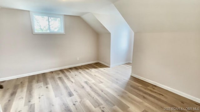 407 Cleveland St, Versailles, MO 65084 - additional living space featuring baseboards, wood finished floors, and lofted ceiling