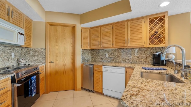 32 Cedar Ct Unit 3A, Lake Ozark, MO 65049 - kitchen featuring decorative backsplash, light stone countertops, a sink, light tile patterned floors, and white appliances
