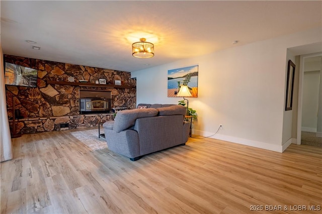 living room with baseboards, light wood finished floors, and a notable chandelier