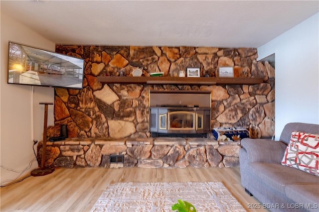 living room with a wood stove and wood finished floors