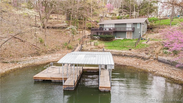 dock area with fence, boat lift, and a deck with water view