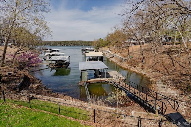 view of dock featuring fence, boat lift, and a water view