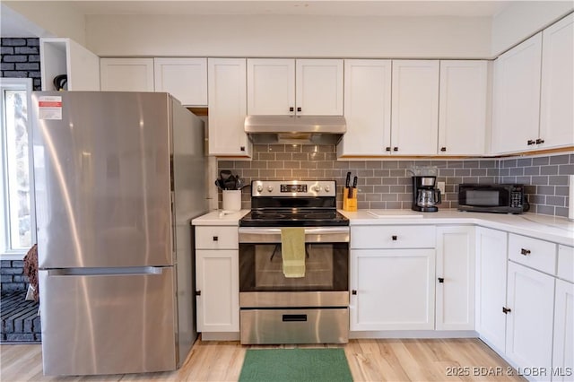 kitchen featuring white cabinetry, under cabinet range hood, and stainless steel appliances