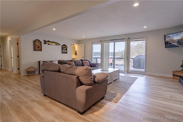 living area featuring baseboards, light wood-type flooring, and recessed lighting