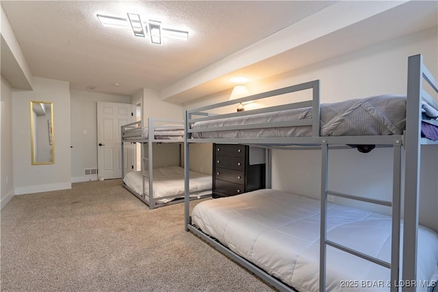 carpeted bedroom featuring baseboards, a textured ceiling, and visible vents